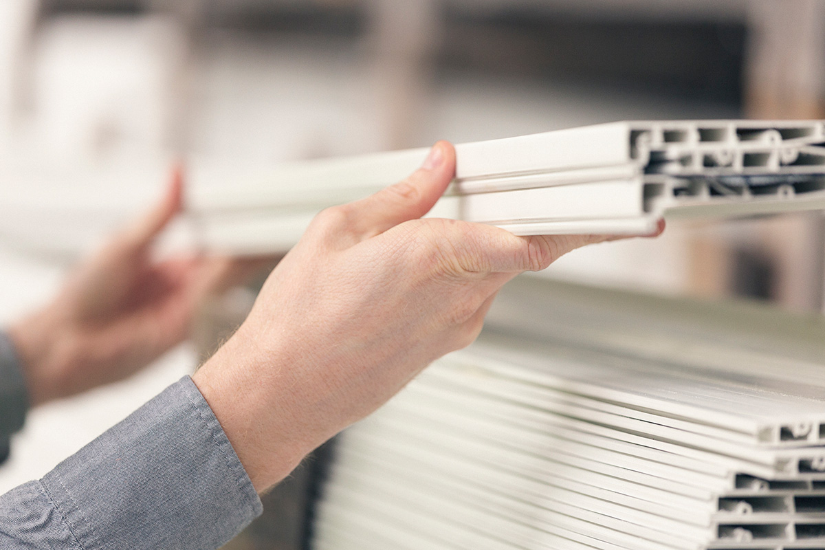Hands holding a stack of custom plastic extrusion profiles, highlighting BioPlastic Solutions' diverse market applications.