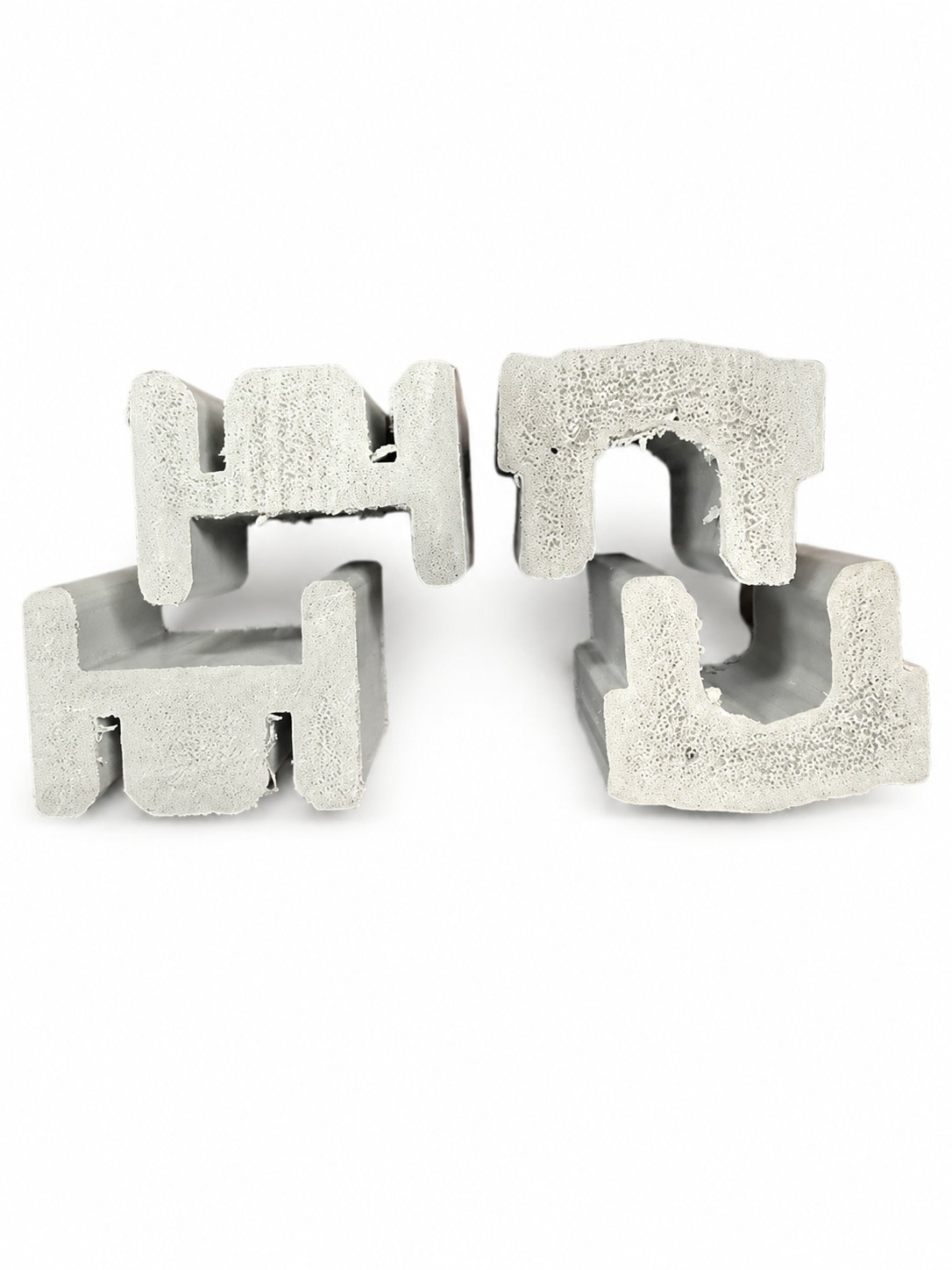 Four sections of foamed composite material, showcasing the texture and shape achieved through twin screw extrusion processing.