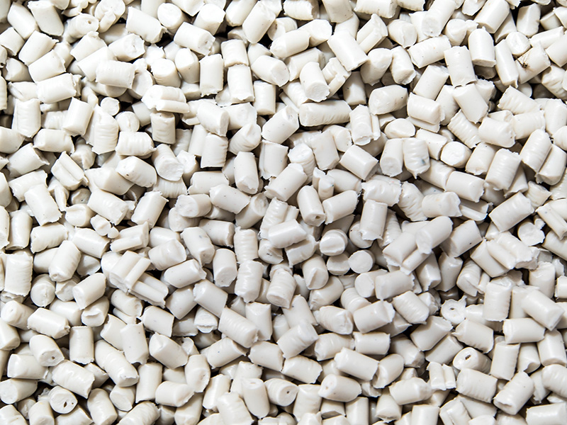 White polyethylene pellets used in plastic extrusion manufacturing.