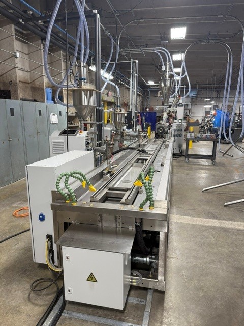 Twin screw extrusion machine in an industrial setting, used for precision processing in custom plastic manufacturing.