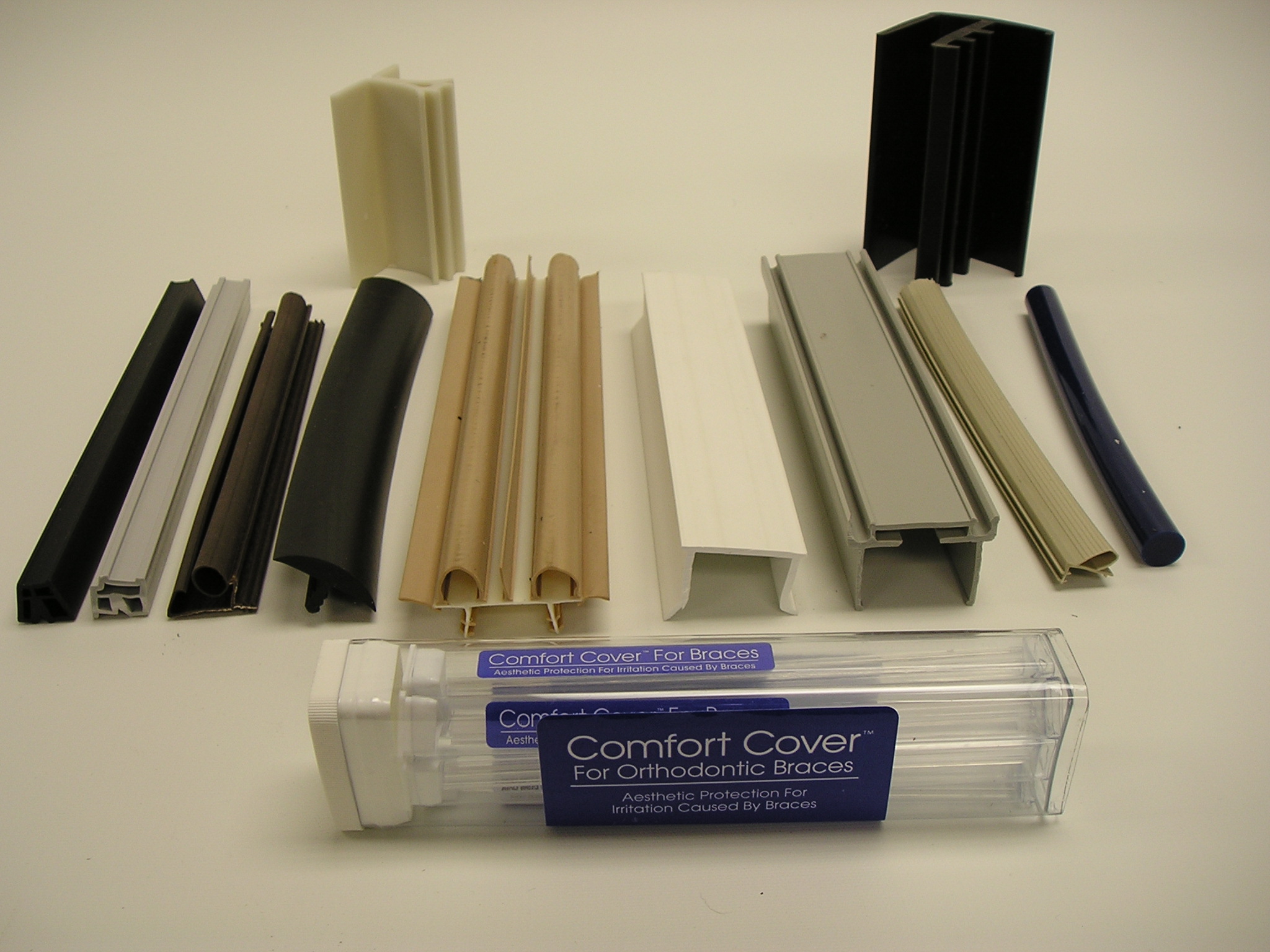 Various custom plastic extrusion profiles in different shapes and colors displayed on a surface, showcasing BioPlastic Solutions' manufacturing capabilities.