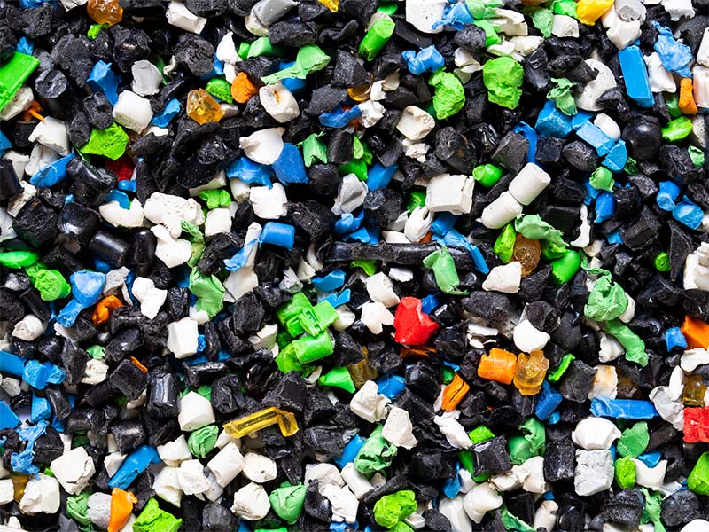 Colorful plastic pellets representing recycled materials used in sustainable resin solutions.